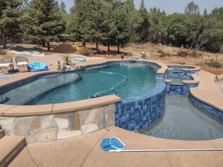 freeform pool with layered waterfall into small water pool