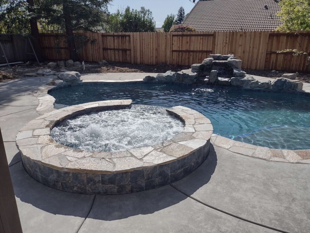 freeform pool with natural rock waterfall, bubbling spa,
