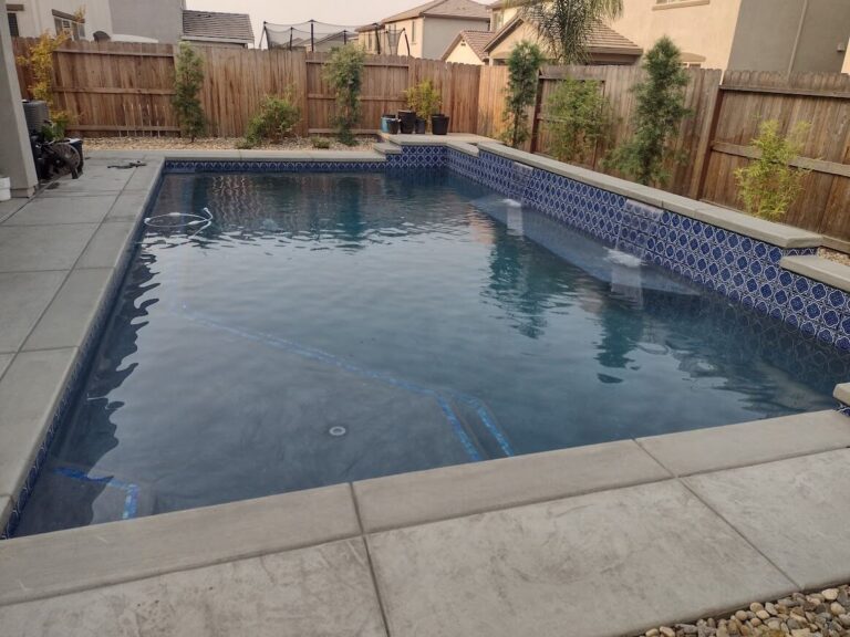 Geometric pool with small waterfall into pool on right side.