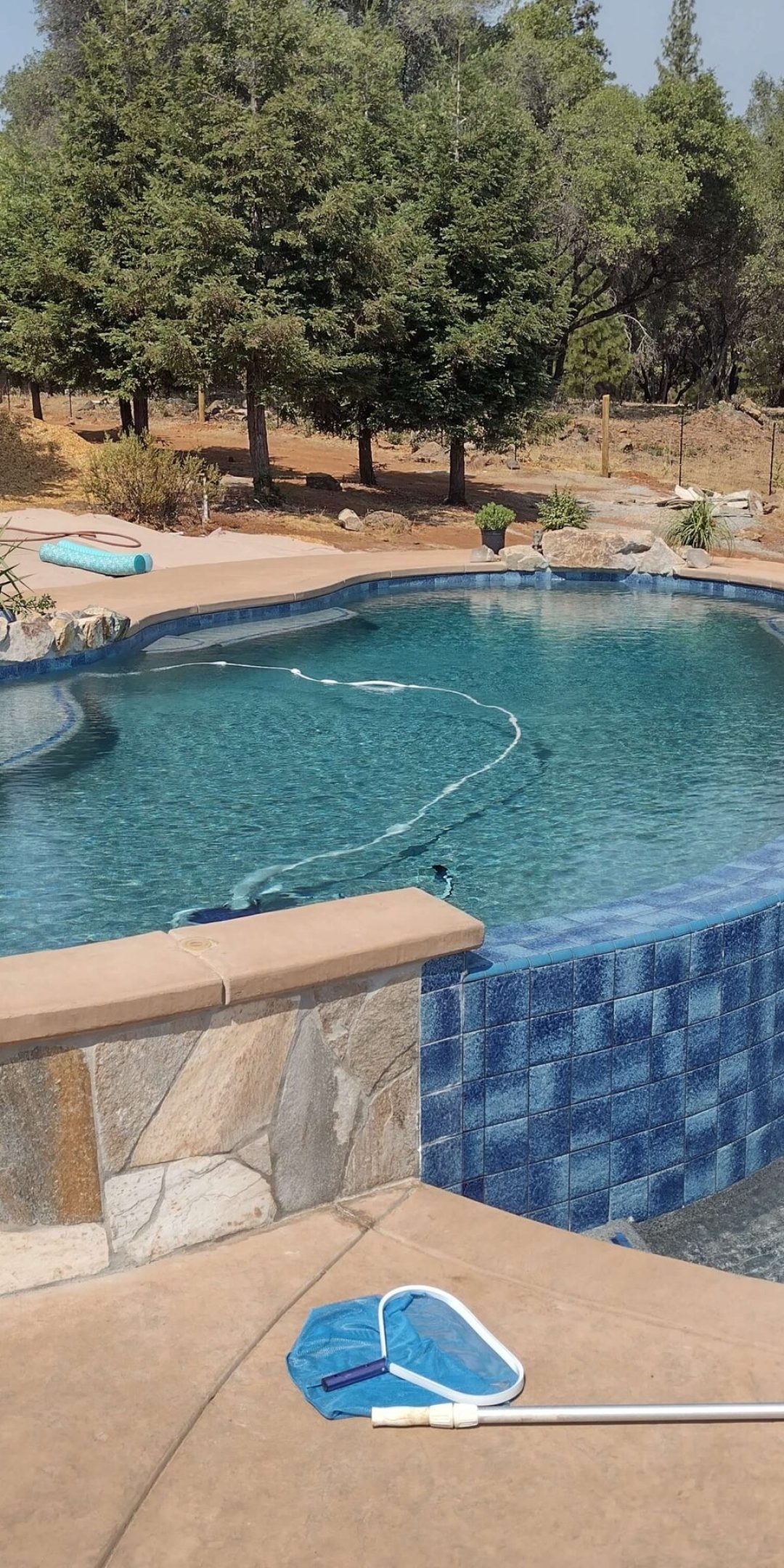 freeform pool with layered waterfall into small water pool
